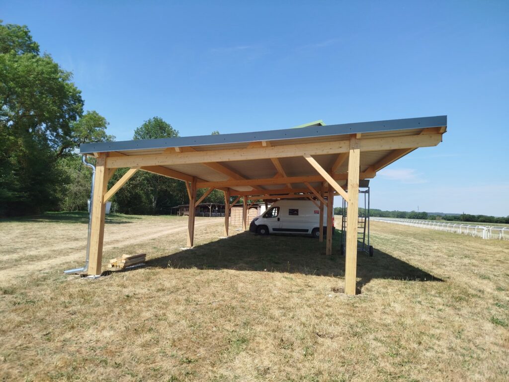 Découvrez la réalisation d'un carport en bois sur l'hippodrome de La Chartre-sur-le-Loir par Loir en Vallée Couverture, spécialiste de la charpente, de la couverture et des constructions bois en Sarthe.